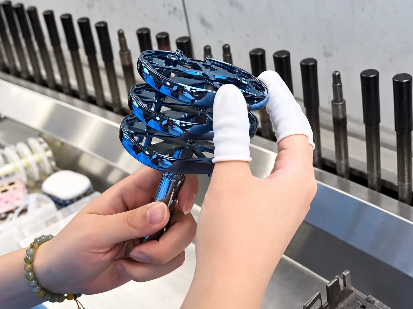 Blue plated housing components being inspected for color and surface finish.
