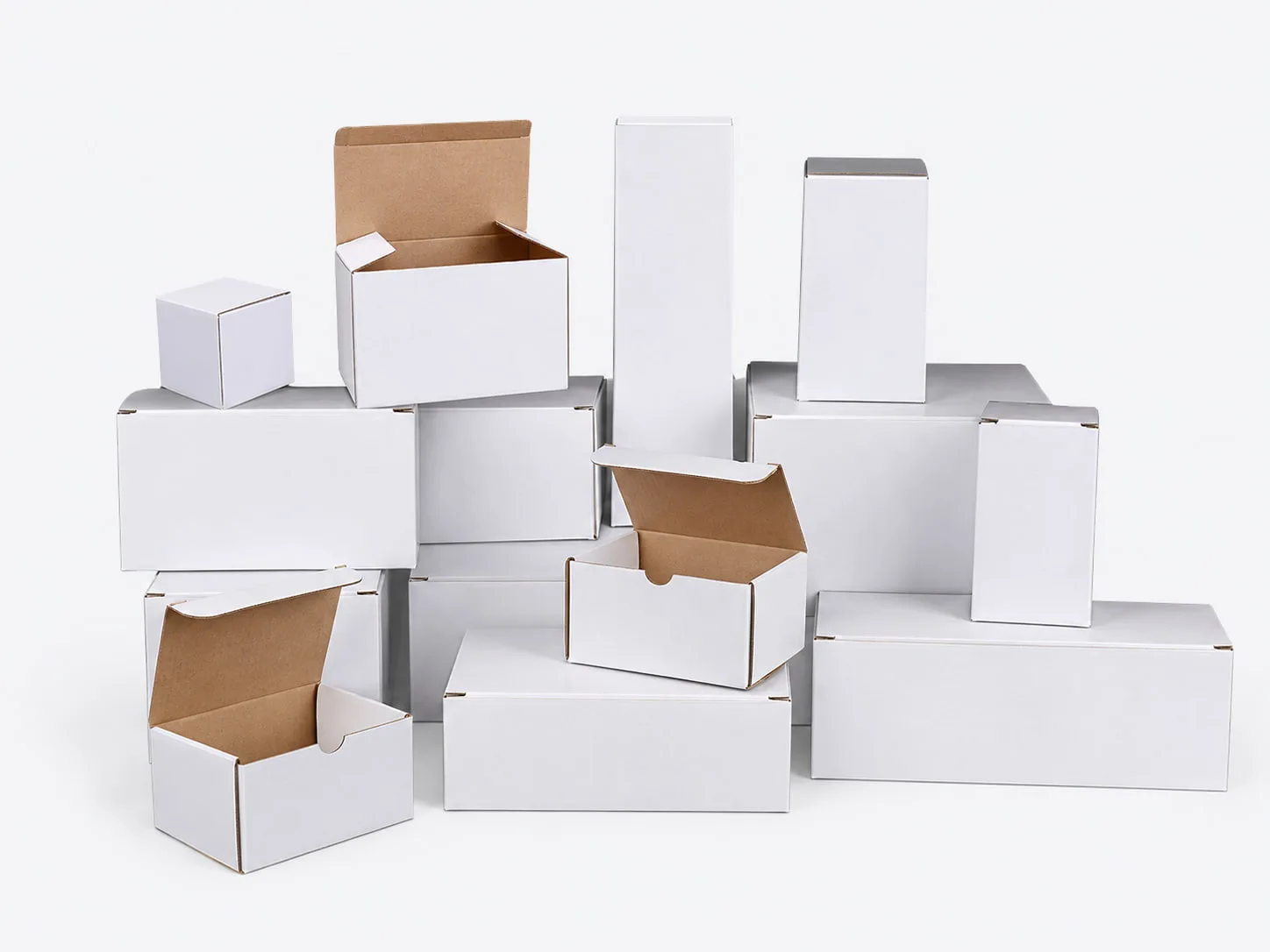 Plain white packaging boxes in assorted sizes, including open boxes with kraft interiors, on a light gray background.