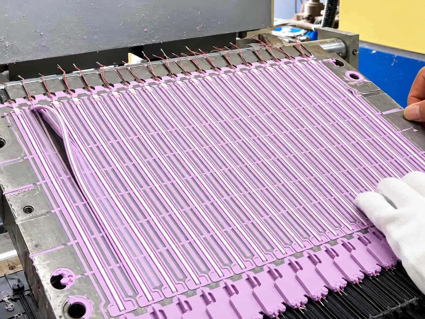 Purple silicone cable components arranged in a production mold during manufacturing.
